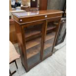 AN EARLY 20TH CENTURY OAK TWO DOOR BOOKCASE, 35" WIDE