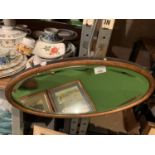 AN OVAL EDWARDIAN BEVEL EDGED MIRROR