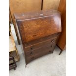 AN OAK BUREAU WITH FALL FRONT AND THREE DRAWERS