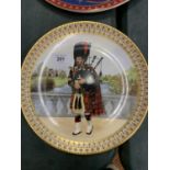A HAND PAINTED DECORATIVE PLATE DEPICTING A HIGHLAND PIPER PAINTED BY MARGARET NANCY BAILEY