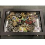 A DISPLAY BOX CONTAINING A LARGE VARIETY OF BROOCHES