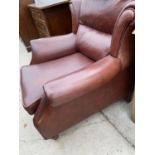A BROWN LEATHER WING BACK ARMCHAIR AND FOOTSTOOL
