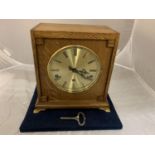 AN OAK CASED BRAVINGTONS LTD (RENOWN SUPER) EIGHT DAY MANTEL CLOCK WITH BRASS CLAW FEET AND KEY