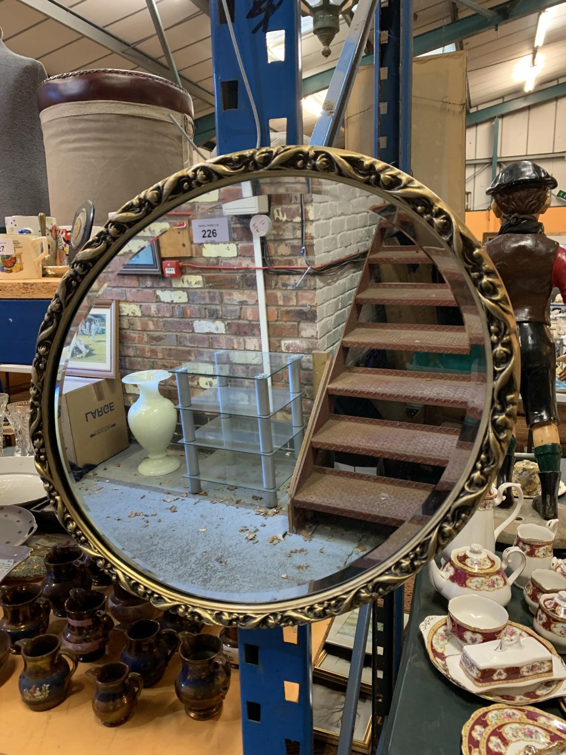 AN OVAL GILT EDGE FRAMED WALL MIRROR