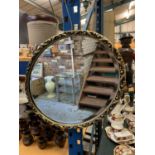 AN OVAL GILT EDGE FRAMED WALL MIRROR