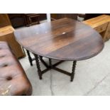 AN OVAL OAK DROP LEAF DINING TABLE ON BARLEY TWIST SUPPORTS