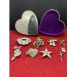 A WHITE METAL HEART SHAPED JEWELLERY BOX WITH EIGHT VARIOUS CLEAR STONE ORNATE BROOCHES