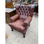 A BUTTON AND WING BACK LEATHER ARMCHAIR ON CABRIOLE SUPPORTS