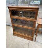 AN EARLY 20TH CENTURY OAK GLAZED AND LEADED GLOBE WERNIKE THREE TIER BOOKCASE, 34" WIDE