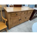 A MODERN LIGHT OAK ANTIQUE STYLE SIDEBOARD ENCLOSING THREE DRAWERS AND THREE CUPBOARDS, 66.5" WIDE