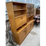 A RETRO TEAK LOUNGE UNIT ENCLOSING SHELVES, GLAZED DOORS, THREE DRAWERS, TWO CUPBOARDS AND A DROP