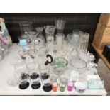 A LARGE ASSORTMENT OF GLASS WARE TO INCLUDE DECANTORS AND GLASSES ETC