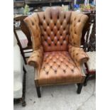 A GEORGE III STYLE WINGED BUTTON BACK LEATHER CHAIR