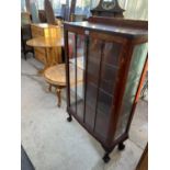 AN OAK CHINA CABINET ON CABRIOLE SUPPORTS WITH TWO GLAZED PANEL DOORS AND SIDES