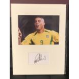 A PHOTOGRAPH OF RONALDO IN A BRAZIL SHIRT WITH HIS AUTOGRAPH IN A MOUNT