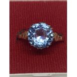 A 9 CARAT GOLD RING WITH A PALE BLUE STONE 3.21G