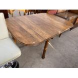 AN OAK DINING TABLE ON FLUTED SUPPORTS