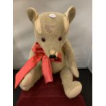 A VINTAGE TEDDY BEAR WITH RED BOW (BELIEVED 1920S)