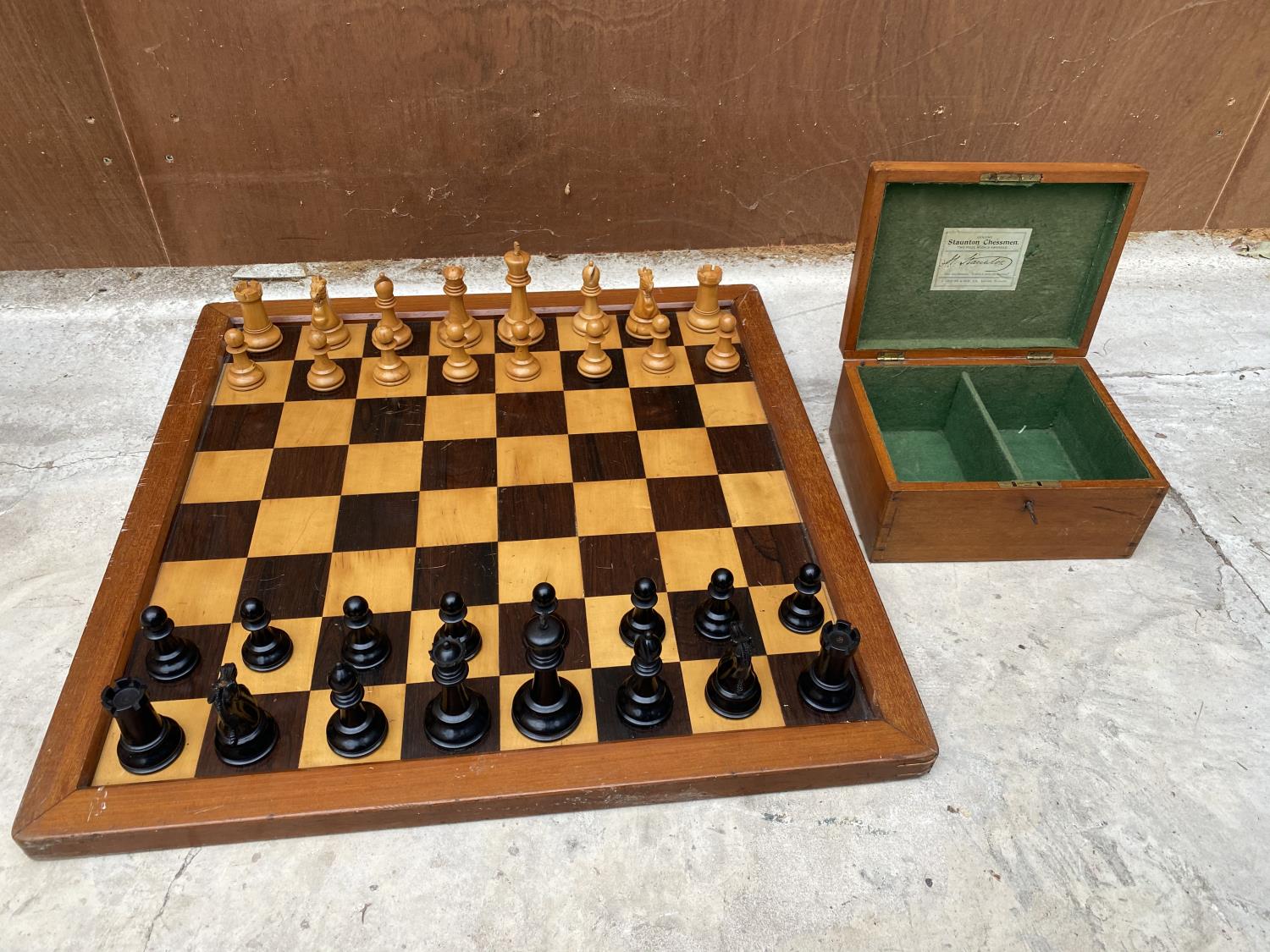 A SET OF STAUNTON CHESSMEN IN A LOCKABLE MAHOGANY CASE WITH KEY TOGETHER WITH A WOODEN CHESS BOARD