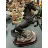 A 'CAPACINO' REARING BLACK HORSE ON A WOODEN PLINTH
