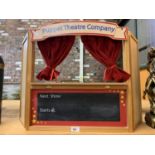 A WOODEN PUPPET THEATRE WITH CHALKBOARD