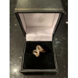A 9 CARAT GOLD BAGUETTE RING IN AN ABSTRACT DESIGN WITH EMERALD CUT DIAMONDS IN A PRESENTATION BOX