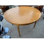 A CIRCULAR TEAK EXTENDING DINING TABLE