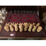 A LARGE CHESS SET WITH A RED AND BLACK BOARD AND MYTHICAL PIECES