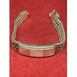 A HEAVY SILVER BRACELET MARKED 925 WITH AN ORNATE STRAP AND A MOTHER OF PEARL DECORATION IN A
