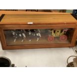 A WOODEN GLASS FRONTED DISPLAY CABINET CONTAINING A FOUR HORSE DRAWN CARRIAGE ORNAMENT