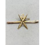 A 9 CARAT GOLD BROOCH WITH A CROSSED PAIR OF SWORDS AND A 5 DESIGN