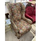 A FLORAL WING BACK ARMCHAIR