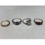 FOUR ASSORTED SILVER RINGS TO INCLUDE RED, CLEAR AND BLUE STONE EXAMPLES