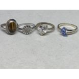 FOUR ASSORTED SILVER RINGS TO INCLUDE RED, BLUE AND CLEAR STONE EXAMPLES