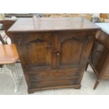 A REPRODUCTION OAK TV/VIDEO CABINET WITH PANELLED DOORS, 37" WIDE