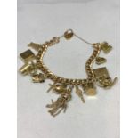 A HEAVY YELLOW METAL CHARM BRACELET EACH LINK STAMPED 9C WITH FOURTEEN 9 CARAT GOLD CHARMS AND A 9