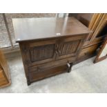 AN OAK JAYCEE TWO DOOR LINENFOLD CABINET WITH SINGLE DRAWER, ON OPEN BASE, 31" WIDE