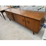 A RETRO G-PLAN TEAK SIDEBAORD ENCLOSING THREE CUPBOARDS AND FOUR DRAWERD, 84" WIDE