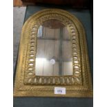 A DECORATIVE YELLOW METAL WALL MIRROR