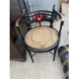 AN EBONISED ELBOW CHAIR A/F