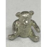 A WHITE METAL TEDDY BEAR APPROXIMATELY 2.5CM HIGH