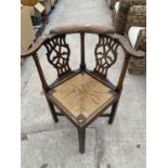 A VICTORIAN OAK RUSH SEATED CORNER CHAIR WITH CARVED AND PIERCED BACK