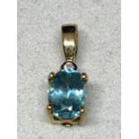A 9 CARAT GOLD PENDANT WITH A PALE BLUE STONE AND CLEAR STONE CHIPS