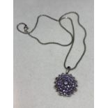 A SILVER NECLACE WITH A FLORAL PENDANT WITH BLUE CHIPS MARKED 925