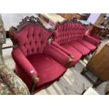 A HEAVILY CARVED MAHOGANY THREE SEATER SOFA AND TWO MATCHING ARMCHAIRS