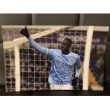 A SIGNED PHOTOGRAPH OF YA YA TOURE WITH A CERTIFICATE OF AUTHENTICITY