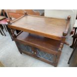 AN OAK OLD CHARM DINNER TROLLEY WITH GLAZED AND LEADED DOORS TO THE BASE