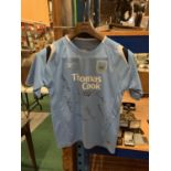 A RETRO MANCHESTER CITY SHIRT SIGNED BY EIGHT OF THE PLAYERS TO INCLUDE FRANCIS LEE AND JOE CORRIGAN