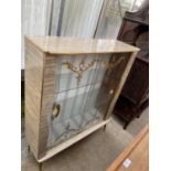 A MID 20TH CENTURY SLIDING GLASS FRONTED DISPLAY CABINET WITH FOLIATE PAINTED DOORS ON TAPERED LEGS,