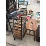 A VINTAGE WOODEN MILKING STOOL AND A METAL WALL MOUNTABLE WINE RACK